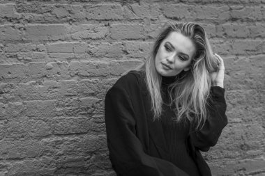 Güz havasının tadını çıkarırken dışarıda poz veren muhteşem bir sarışın model.