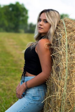 Sarışın bir çiftçinin kızı çiftlik ortamında poz veriyor.