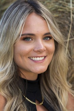 Sarışın bir çiftçinin kızı çiftlik ortamında poz veriyor.