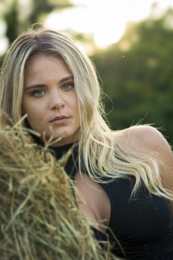 Sarışın bir çiftçinin kızı çiftlik ortamında poz veriyor.