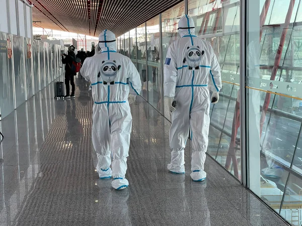 Αξιωματούχοι Επικίνδυνα Κοστούμια Συνοδεύουν Αφικνούμενους Επιβάτες Στο Πεκίνο Capital Airport — Φωτογραφία Αρχείου