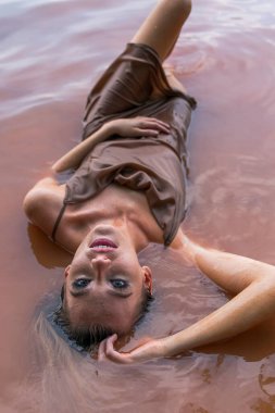 Muhteşem sarışın bir model gölde güzel bir gün geçiriyor.