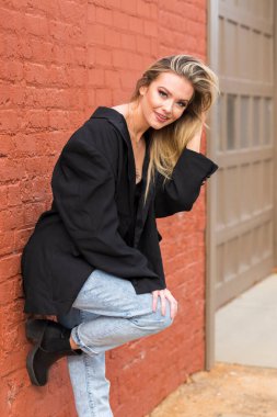 Güz havasının tadını çıkarırken dışarıda poz veren muhteşem bir sarışın model.