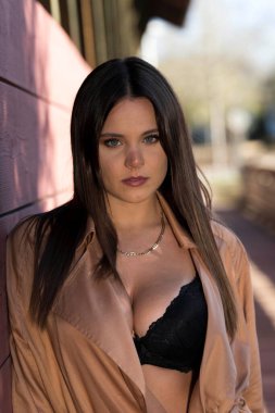 Muhteşem bir esmer model, sonbahar havasının tadını çıkarırken dışarıda poz veriyor.