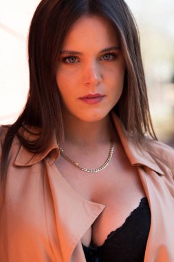 Muhteşem bir esmer model, sonbahar havasının tadını çıkarırken dışarıda poz veriyor.