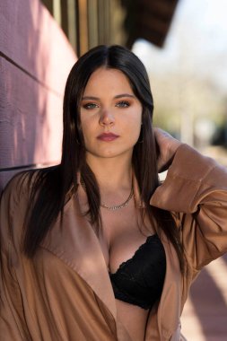 Muhteşem bir esmer model, sonbahar havasının tadını çıkarırken dışarıda poz veriyor.