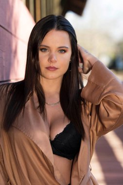 Muhteşem bir esmer model, sonbahar havasının tadını çıkarırken dışarıda poz veriyor.