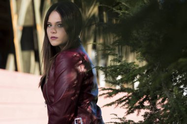 Muhteşem bir esmer model, sonbahar havasının tadını çıkarırken dışarıda poz veriyor.