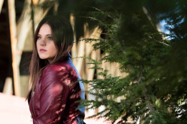 Muhteşem bir esmer model, sonbahar havasının tadını çıkarırken dışarıda poz veriyor.