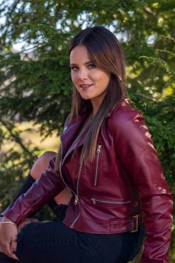 Muhteşem bir esmer model, sonbahar havasının tadını çıkarırken dışarıda poz veriyor.