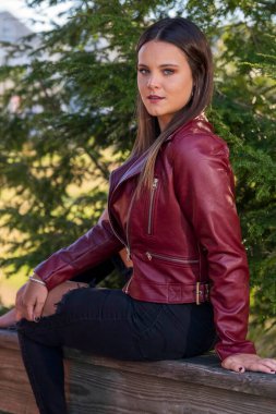 Muhteşem bir esmer model, sonbahar havasının tadını çıkarırken dışarıda poz veriyor.