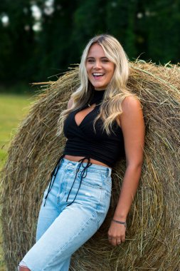 Sarışın bir çiftçinin kızı çiftlik ortamında poz veriyor.