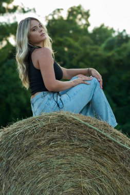 Sarışın bir çiftçinin kızı çiftlik ortamında poz veriyor.