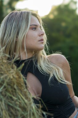 Sarışın bir çiftçinin kızı çiftlik ortamında poz veriyor.