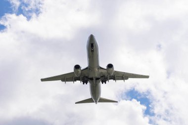 Havaalanına öğleden sonra gökyüzüne inen ticari bir uçak.