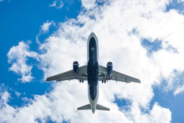 午後の空に対する空港に着陸する民間航空機 — ストック写真