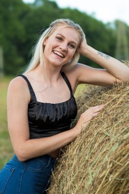 Sarışın bir çiftçinin kızı çiftlik ortamında poz veriyor.