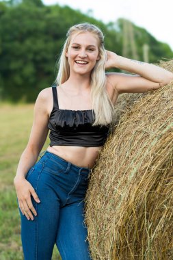 Sarışın bir çiftçinin kızı çiftlik ortamında poz veriyor.