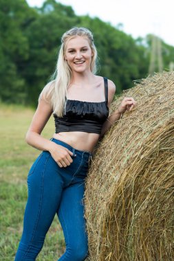 Sarışın bir çiftçinin kızı çiftlik ortamında poz veriyor.