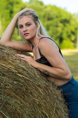 Sarışın bir çiftçinin kızı çiftlik ortamında poz veriyor.