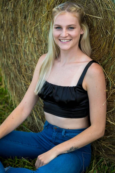 Sarışın bir çiftçinin kızı çiftlik ortamında poz veriyor.