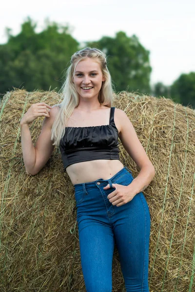 Sarışın bir çiftçinin kızı çiftlik ortamında poz veriyor.