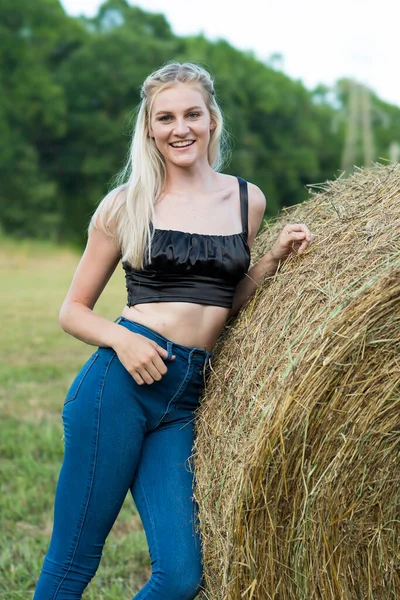 Sarışın bir çiftçinin kızı çiftlik ortamında poz veriyor.