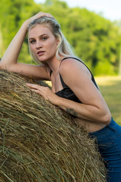 Sarışın bir çiftçinin kızı çiftlik ortamında poz veriyor.