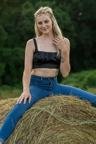 Sarışın bir çiftçinin kızı çiftlik ortamında poz veriyor.