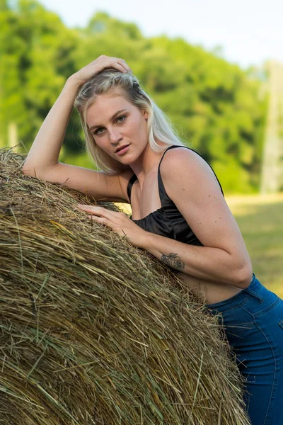 Sarışın bir çiftçinin kızı çiftlik ortamında poz veriyor.