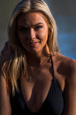 Muhteşem sarışın bir bikini modeli göl kenarında poz verirken yaz havasının tadını çıkarıyor..