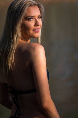 Muhteşem sarışın bir bikini modeli göl kenarında poz verirken yaz havasının tadını çıkarıyor..