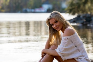 Muhteşem sarışın bir bikini modeli göl kenarında poz verirken yaz havasının tadını çıkarıyor..