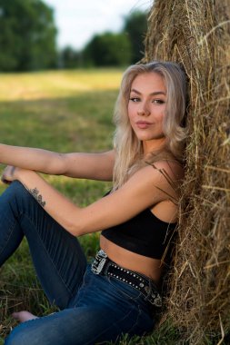 Sarışın bir çiftçinin kızı çiftlik ortamında poz veriyor.