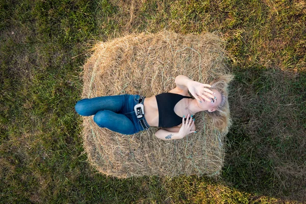 Sarışın bir çiftçinin kızı çiftlik ortamında poz veriyor.