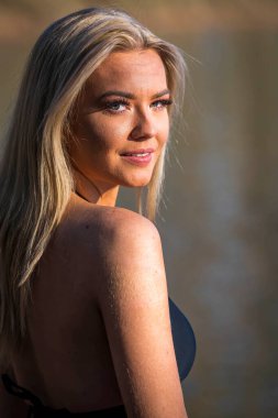 Muhteşem sarışın bir bikini modeli göl kenarında poz verirken yaz havasının tadını çıkarıyor..