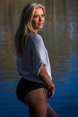 Muhteşem sarışın bir bikini modeli göl kenarında poz verirken yaz havasının tadını çıkarıyor..