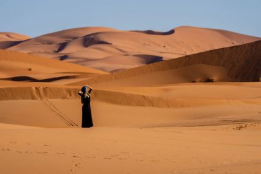 Fas 'taki büyük Sahra Çölü' ndeki kum tepelerine karşı güzel bir model poz veriyor.