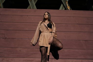 Muhteşem bir esmer model, sonbahar havasının tadını çıkarırken dışarıda poz veriyor.