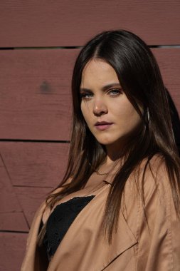 Muhteşem bir esmer model, sonbahar havasının tadını çıkarırken dışarıda poz veriyor.