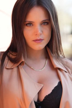 Muhteşem bir esmer model, sonbahar havasının tadını çıkarırken dışarıda poz veriyor.