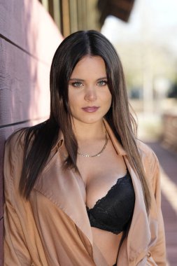 Muhteşem bir esmer model, sonbahar havasının tadını çıkarırken dışarıda poz veriyor.