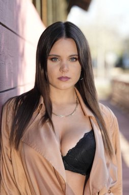 Muhteşem bir esmer model, sonbahar havasının tadını çıkarırken dışarıda poz veriyor.