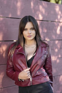 Muhteşem bir esmer model, sonbahar havasının tadını çıkarırken dışarıda poz veriyor.