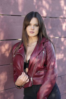 Muhteşem bir esmer model, sonbahar havasının tadını çıkarırken dışarıda poz veriyor.