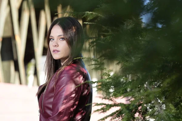 Muhteşem bir esmer model, sonbahar havasının tadını çıkarırken dışarıda poz veriyor.