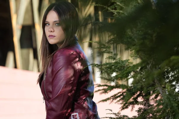 Muhteşem bir esmer model, sonbahar havasının tadını çıkarırken dışarıda poz veriyor.