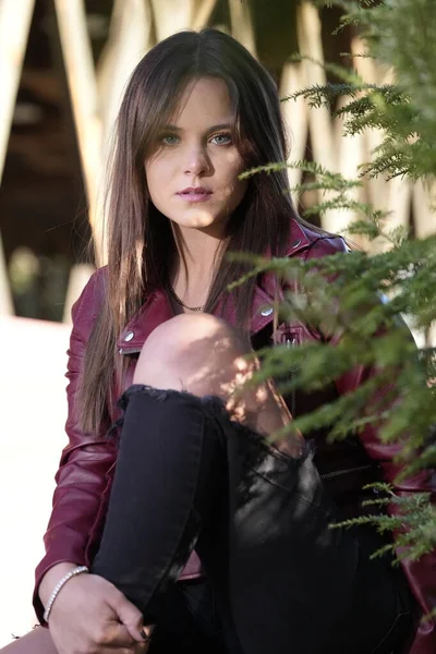 Muhteşem bir esmer model, sonbahar havasının tadını çıkarırken dışarıda poz veriyor.