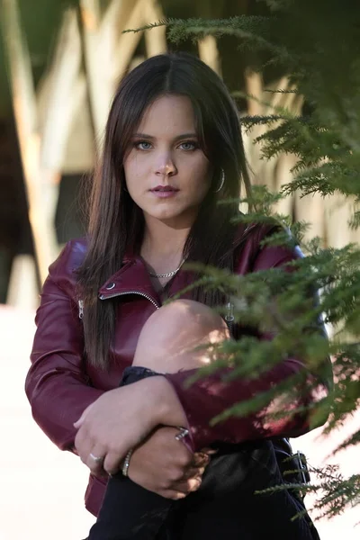 Muhteşem bir esmer model, sonbahar havasının tadını çıkarırken dışarıda poz veriyor.