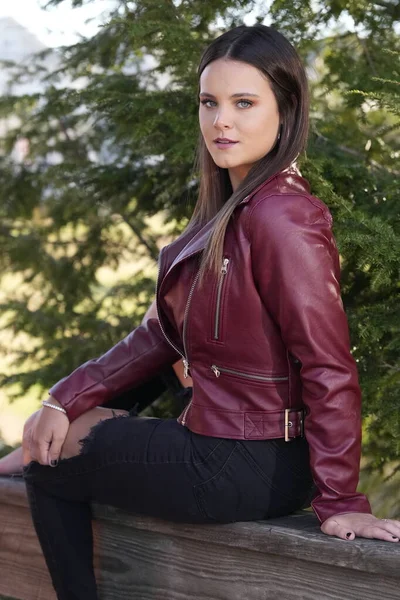 Muhteşem bir esmer model, sonbahar havasının tadını çıkarırken dışarıda poz veriyor.